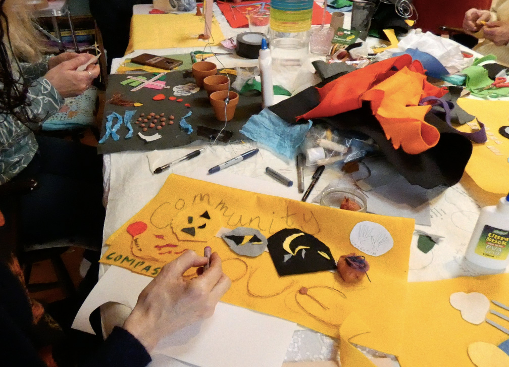 a yellow felt artwork with the word community written on it