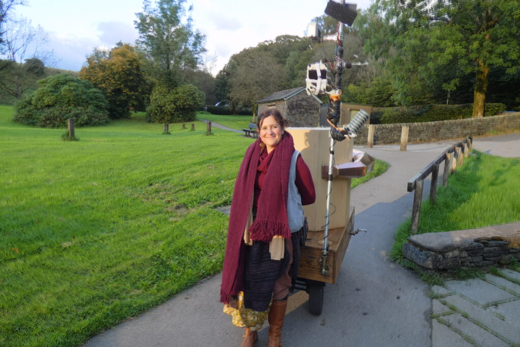 Rachel Jacobs with Future Machine on a path with grass on either side and trees in the background