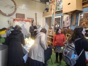 Rachel Jacobs in her studio with people looking at the artworks