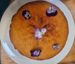 A homemade Honey and Orange cake with violas on the top