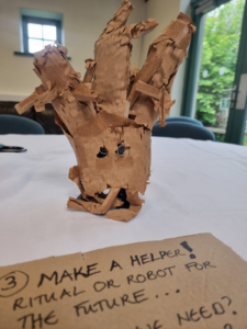 The Tree Robot with a sign saying 'Make A Helper!'
