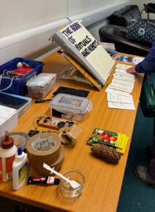 The Book of Rituals and Robots, small booklets with the stories from a previous workshop and a selection of electronics and mechanical kit on a table
